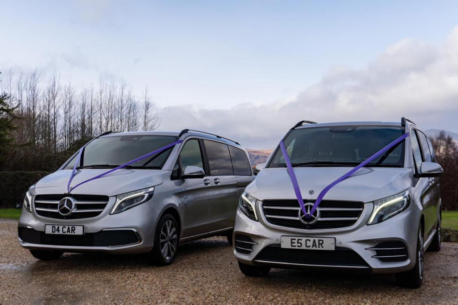 Two silver Mercedes V Classes with purple ribbon